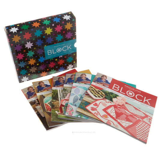A boxed craft block set with a colorful patterned box and several fanned-out magazines showing quilt block designs on a white background.
[image_link]