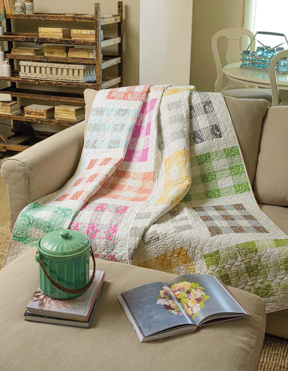 Quilt draped over a sofa with books and a teapot on a table in a cozy living room.
[additional_image_link]