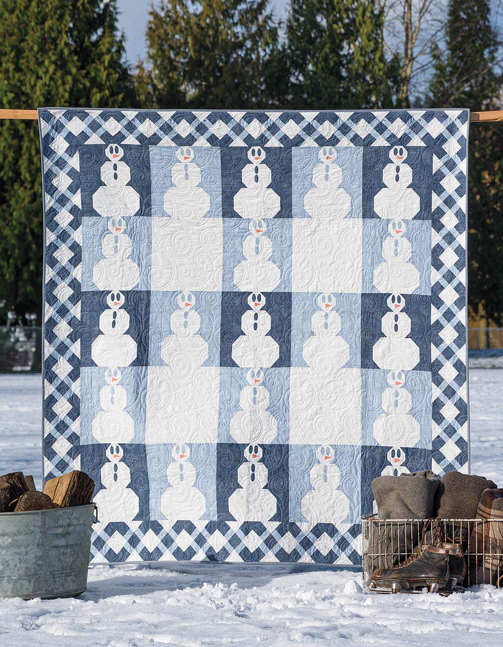 Quilt with snowman pattern displayed outdoors in a snowy landscape
[additional_image_link]