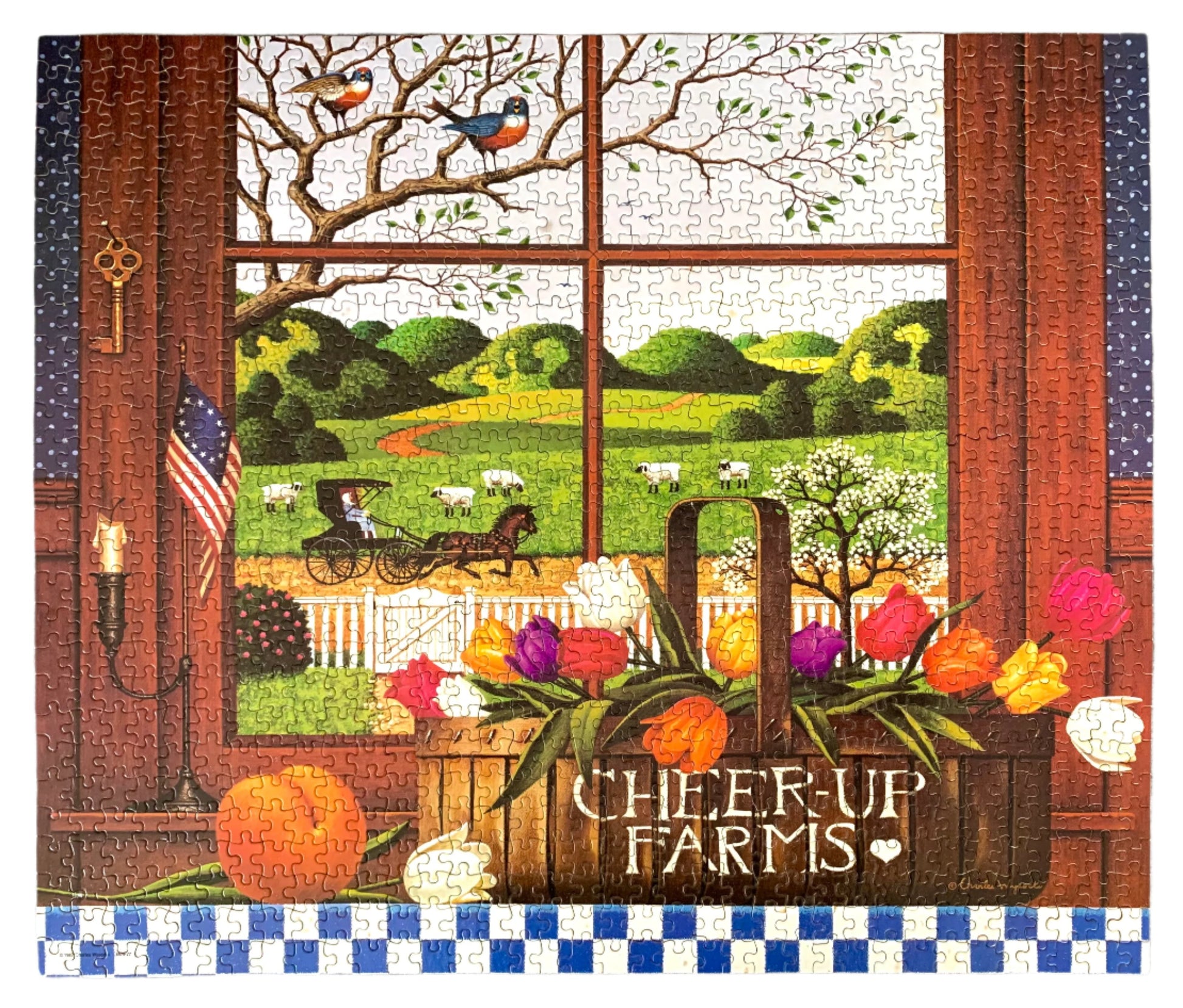 A jigsaw puzzle depicting a rural scene with a farmhouse, trees, a red barn, and a quilt hanging on the wall, titled 'Cheer-up Farms' by Charles Wysocki.
Photo by Karen King [image_link]