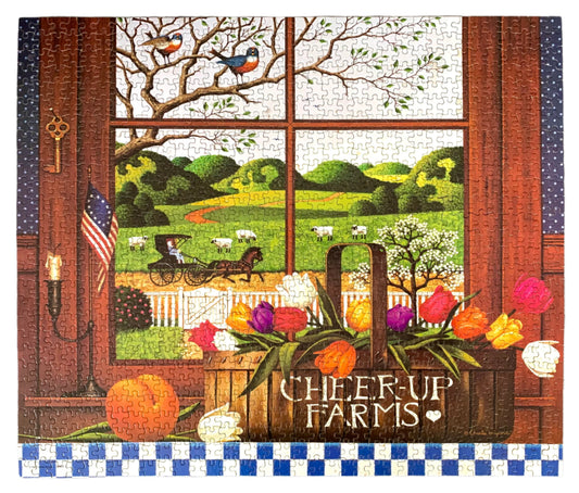 A jigsaw puzzle depicting a rural scene with a farmhouse, trees, a red barn, and a quilt hanging on the wall, titled 'Cheer-up Farms' by Charles Wysocki.
Photo by Karen King [image_link]