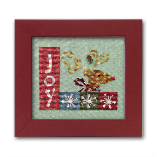 A cross-stitch kit depicting a reindeer, snowflakes, and the word 'joy', framed in a red border.
Photo by JustAnotherButtonCompany.com [image_link]