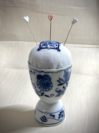 Hand stitched Delft pincushion in a vintage blue Danube double egg cup on white linen, with a signature pattern by Blue Danube in Japan.
Photos by The Surgeon's Knots [additional_image_link]
