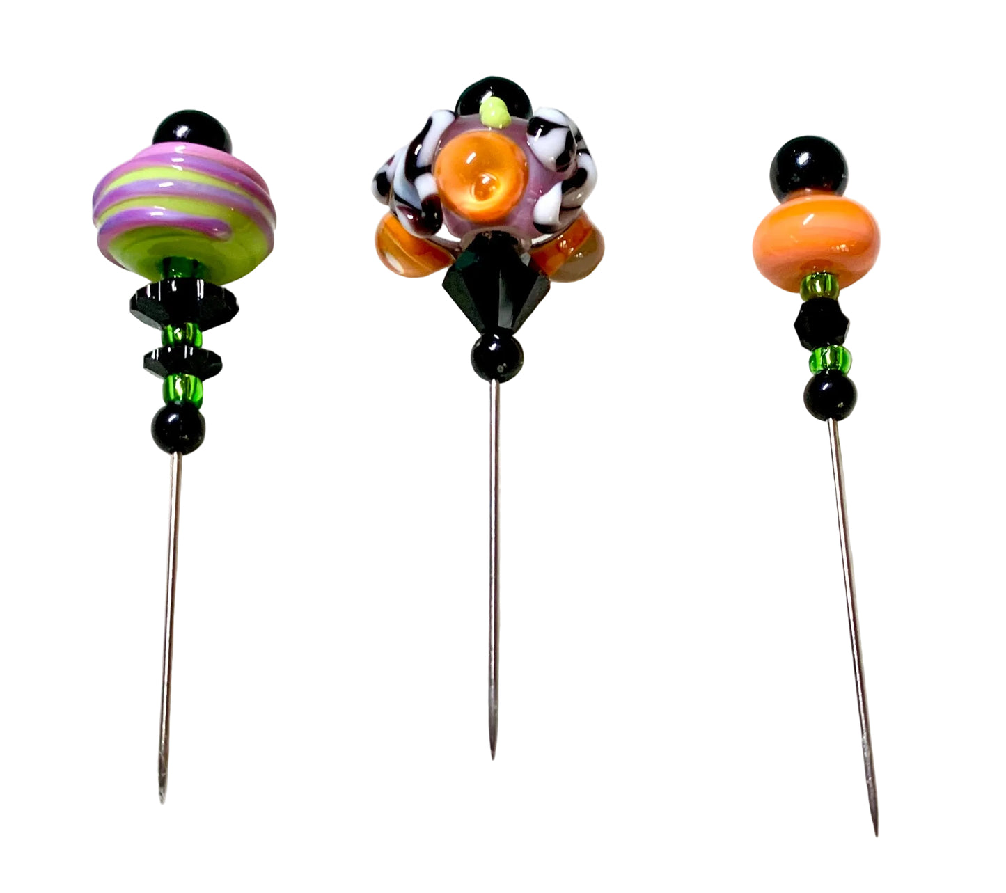 Three handmade glass pins with colorful beads and decorative tops, displayed on a white surface.
[additional_image_link]