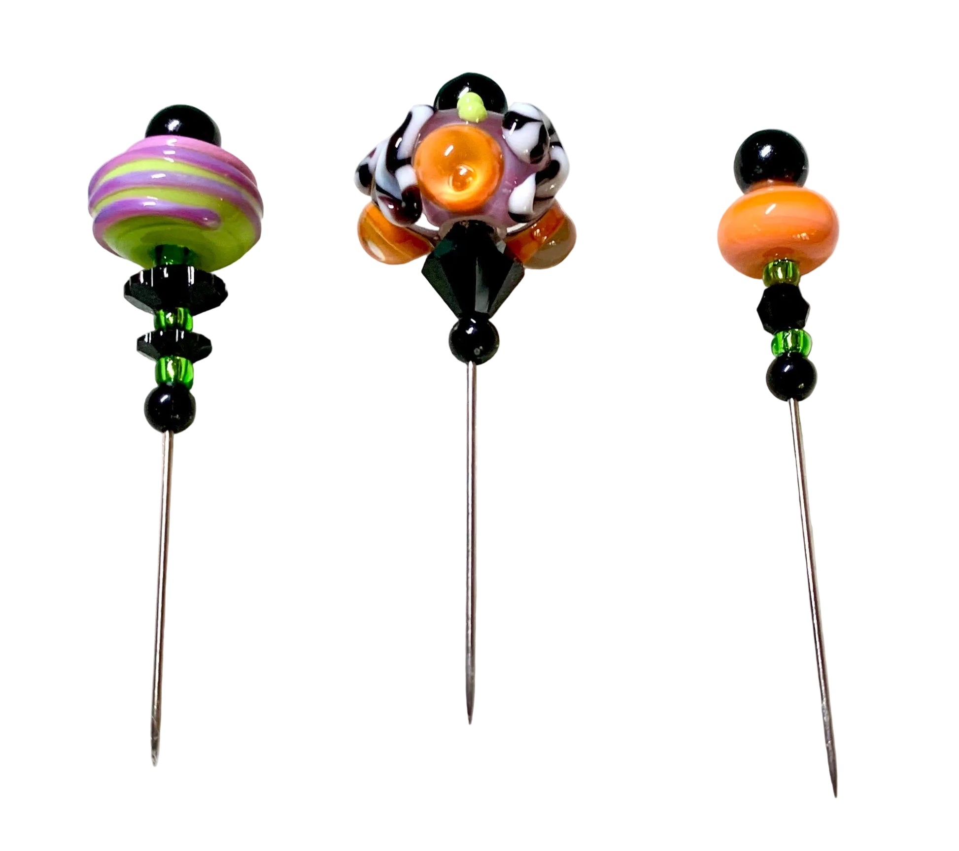 Three handmade glass pins with colorful beads and decorative tops, displayed on a white surface.
[additional_image_link]