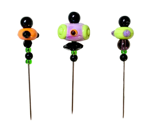 Three handmade glass bead pins with long metal needles, decorated with colorful beads on a white background.
[image_link]