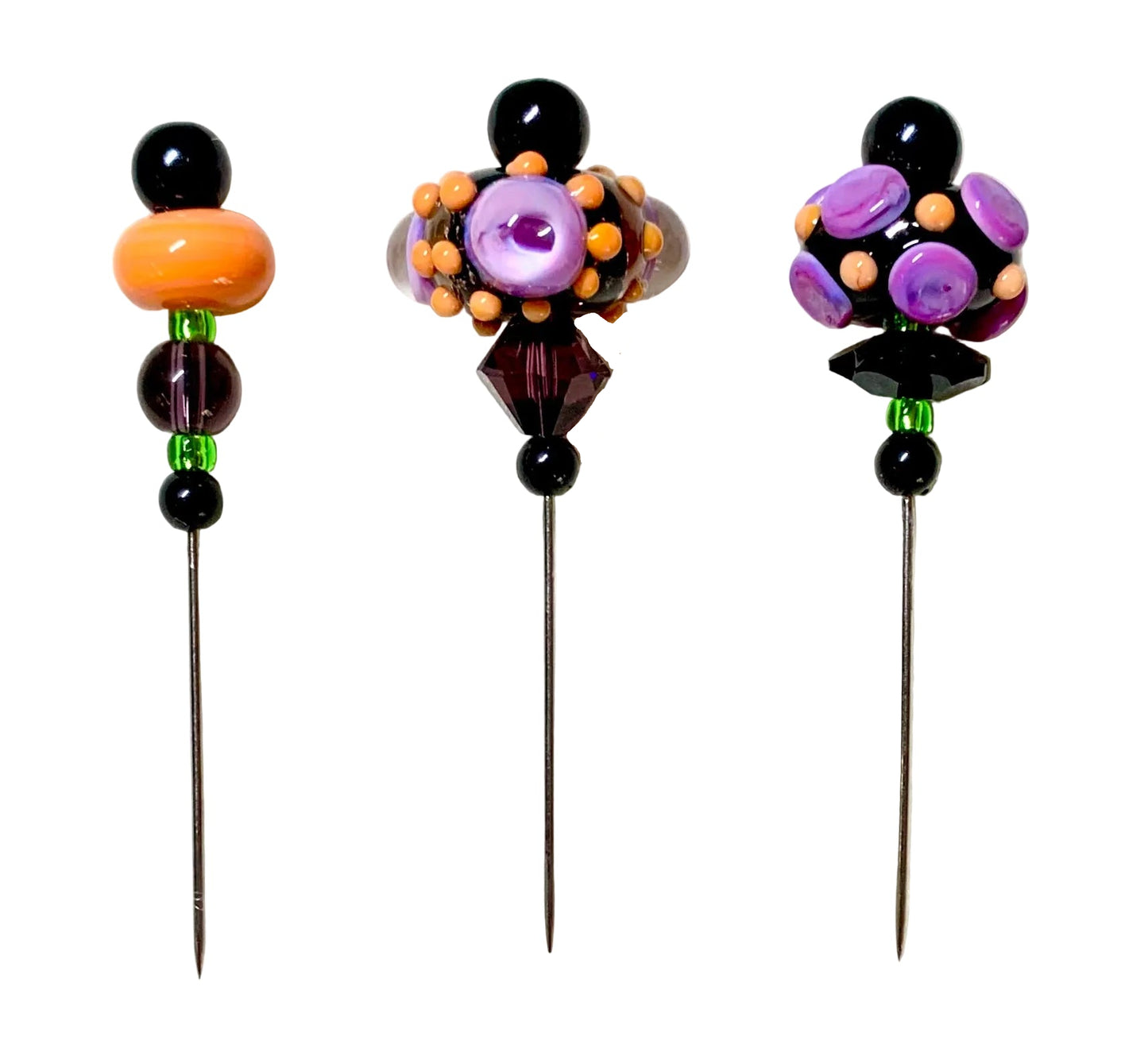 Three decorative glass sewing pins with long metal shafts, decorated with colorful beads in purple, orange, black, and green on a white background.
[additional_image_link]