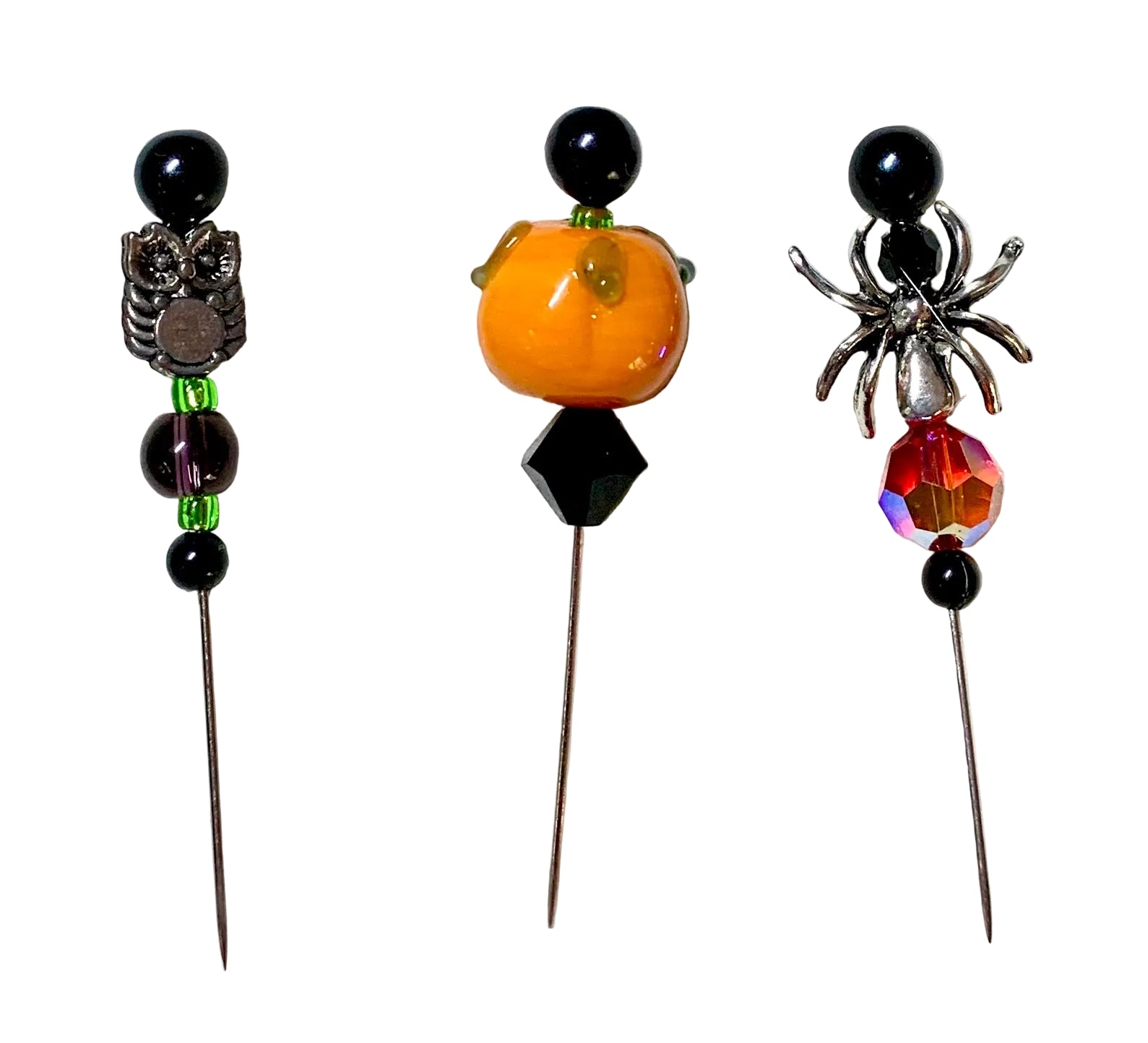 Three Halloween-themed beaded beads on metal pins, featuring a silver owl, a small orange pumpkin, and a silver spider wit 3h a red crystal bead, displayed on a white background.
[image_link]