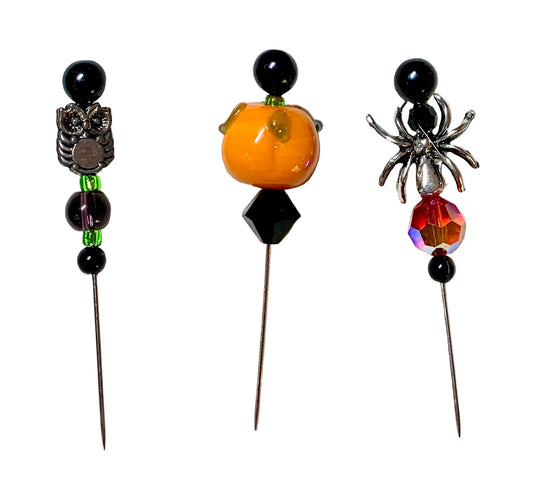 Three Halloween-themed beaded beads on metal pins, featuring a silver owl, a small orange pumpkin, and a silver spider wit 3h a red crystal bead, displayed on a white background.
[image_link]