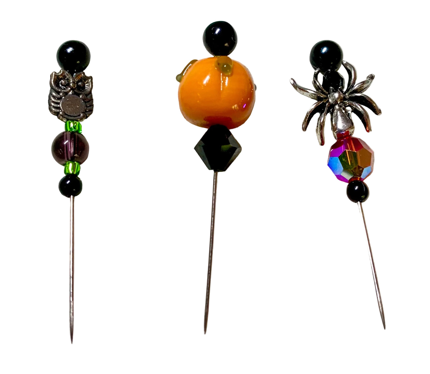 Three Halloween-themed beaded pins with metal spider, pumpkin, and owl embellishments on long silver needles, displayed on a white background.
[additional_image_link]