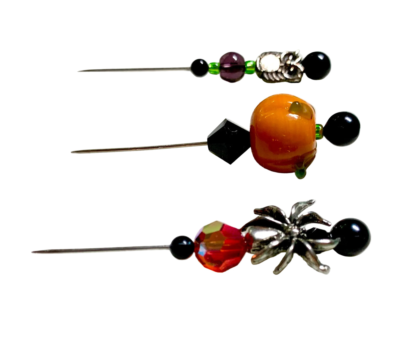 Three decorative sewing or embroidery needles with colorful beads , a lampwork pumpkin and metal spider and owl charms, displayed on a white surface.
[additional_image_link]