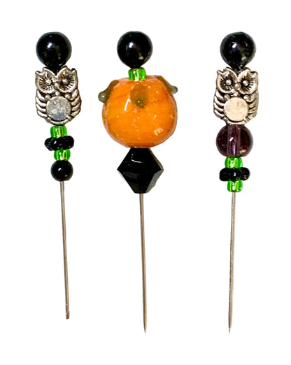 Three decorative sewing pins on metal needles, featuring owl and pumpkin bead designs on a white background.
[additional_image_link]