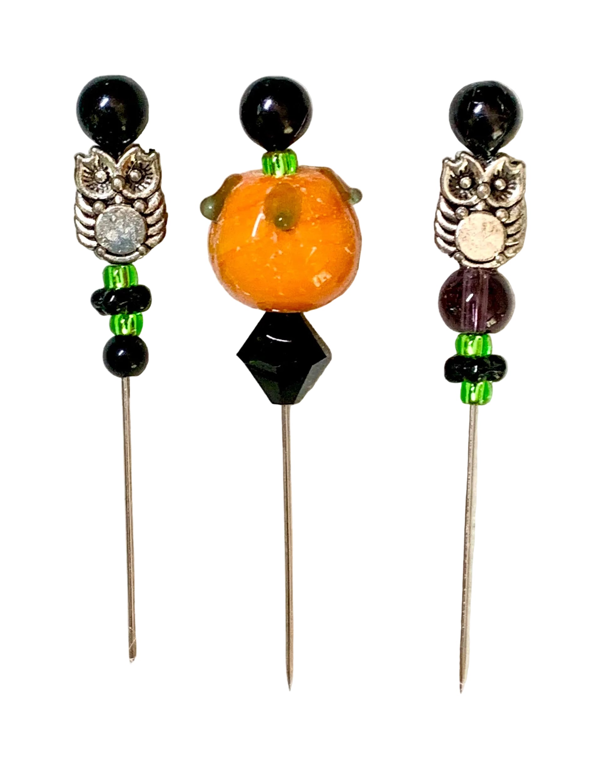 Three decorative sewing pins with black beads, silver owl charms, green spacer beads, and a central orange pumpkin bead, displayed on a white background.
[image_link]