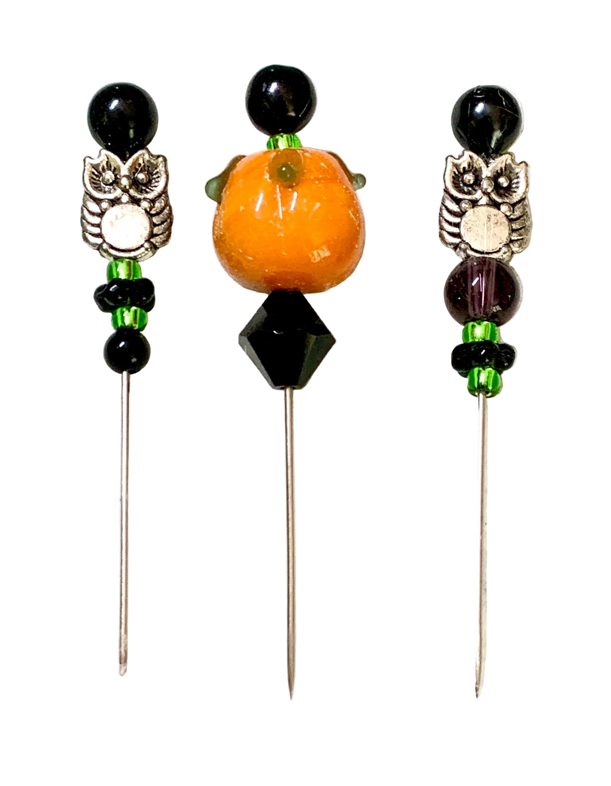 Three beaded pins with owl charms, displayed on a white surface. The left and right pins feature black beads, silver owl charms, and green accents.
[additional_image_link]