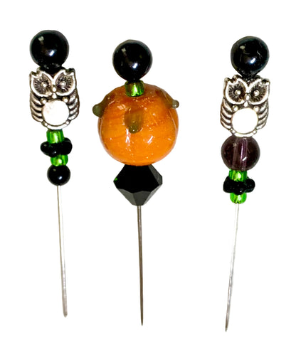 Three Halloween-themed beaded pins on a white background. The left and right pins features a silver owl with green and black beads. The middle bead is a pumpkin.
[additional_image_link]