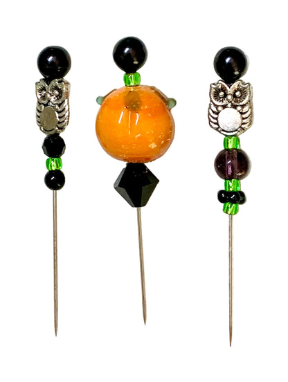 Three decorative beaded pins with owl charms and a lampwork pumpkin, displayed on a white background.
[additional_image_link]