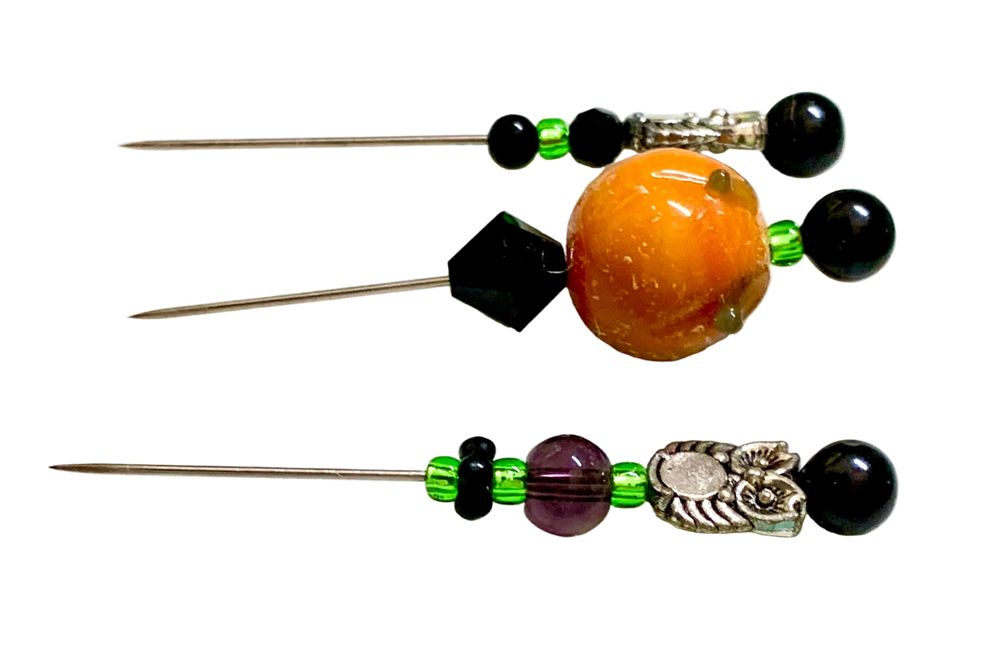 Three beaded sewing pins with black beads, green accent beads, a large orange pumpkin glass bead, a purple faceted bead, and silver-toned metal owl details, displayed on a white background.
[additional_image_link]