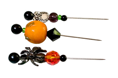 Three decorative sewing pins with Halloween-themed beads and spider, owl and pumpkin charms, displayed on a white background.
[additional_image_link]