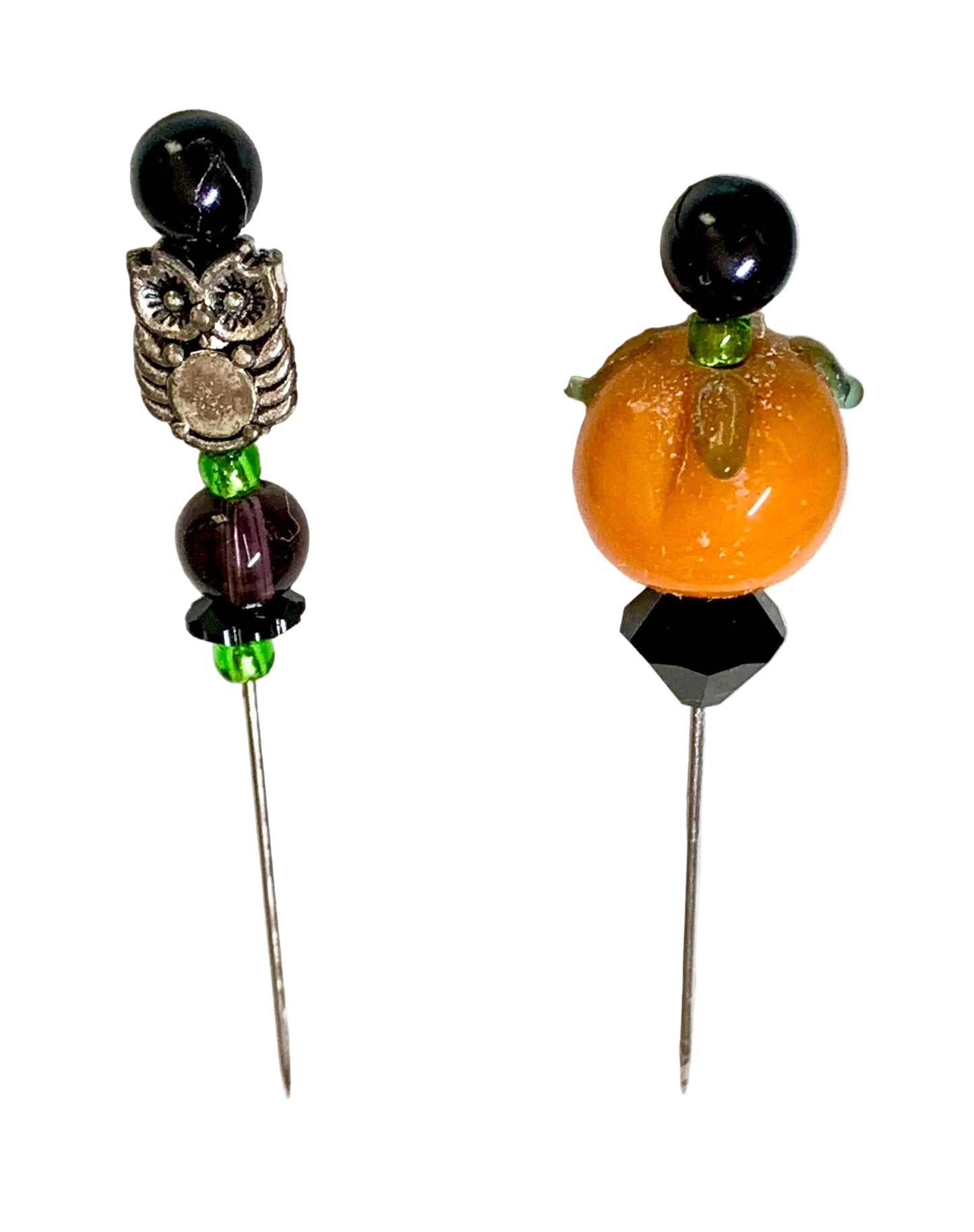 Two beaded pins on a white background. One pin a black bead, a silver owl charm, and dark purple beads with green accents. The other is a pumpkin.
[additional_image_link]