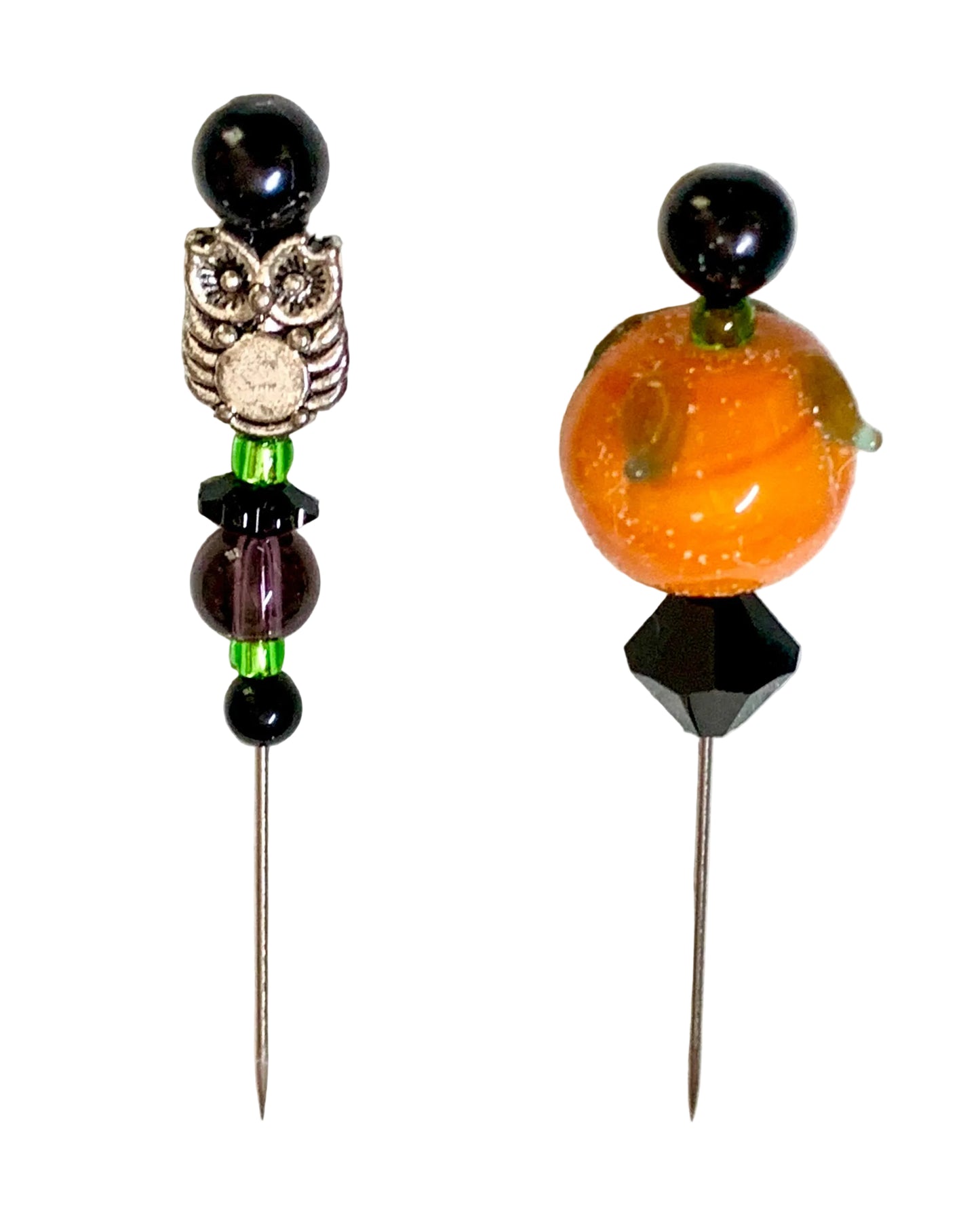 Two decorative sewing pins with beaded tops on a white background. One pin features a silver owl charm with black beads and green spacer beads. The other is a pumpkin.
[additional_image_link]