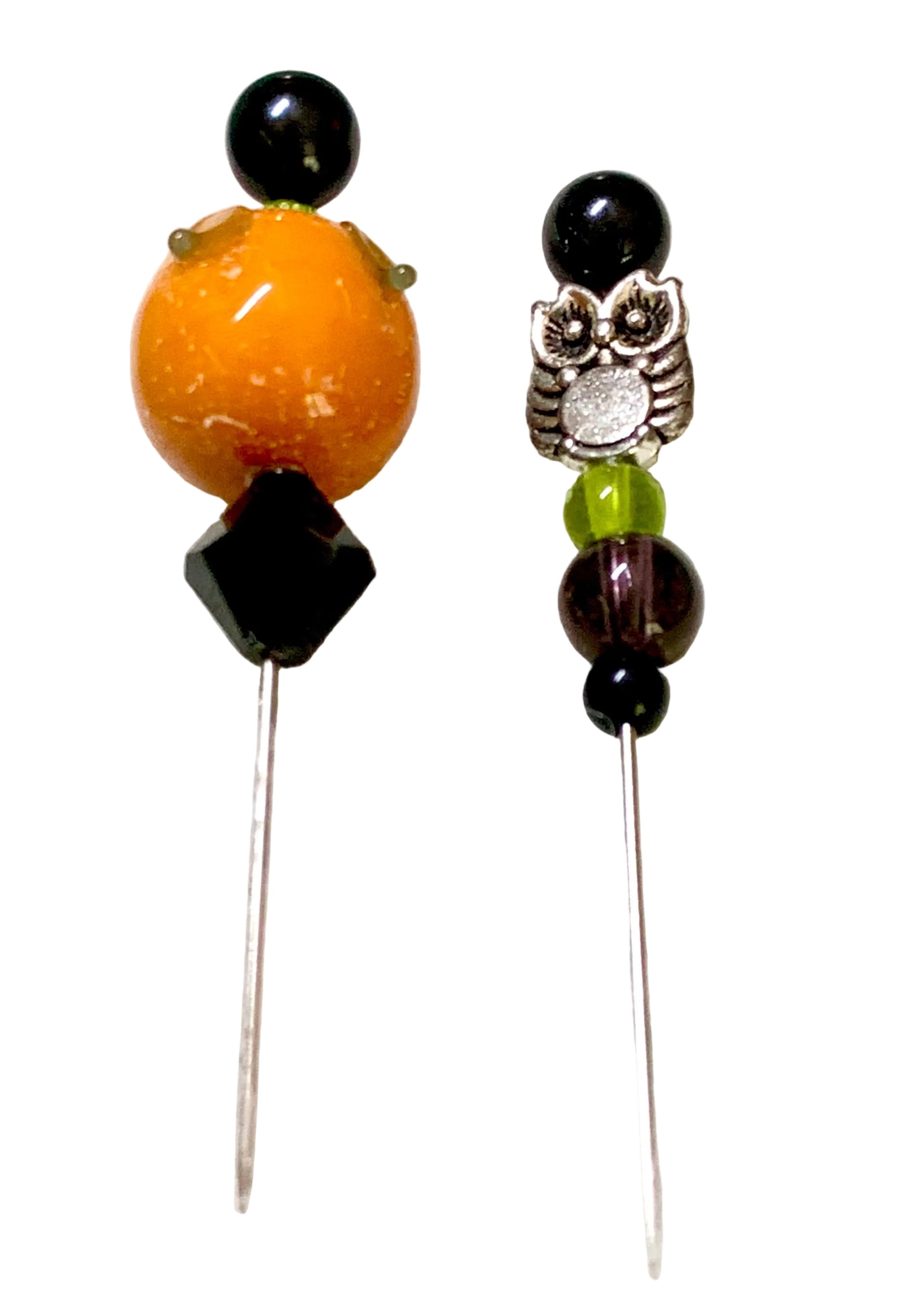 Two beaded sewing pins, featuring black beads, a large orange pumpkin bead, a black faceted bead, and a silver owl charm on a white background.
[additional_image_link]