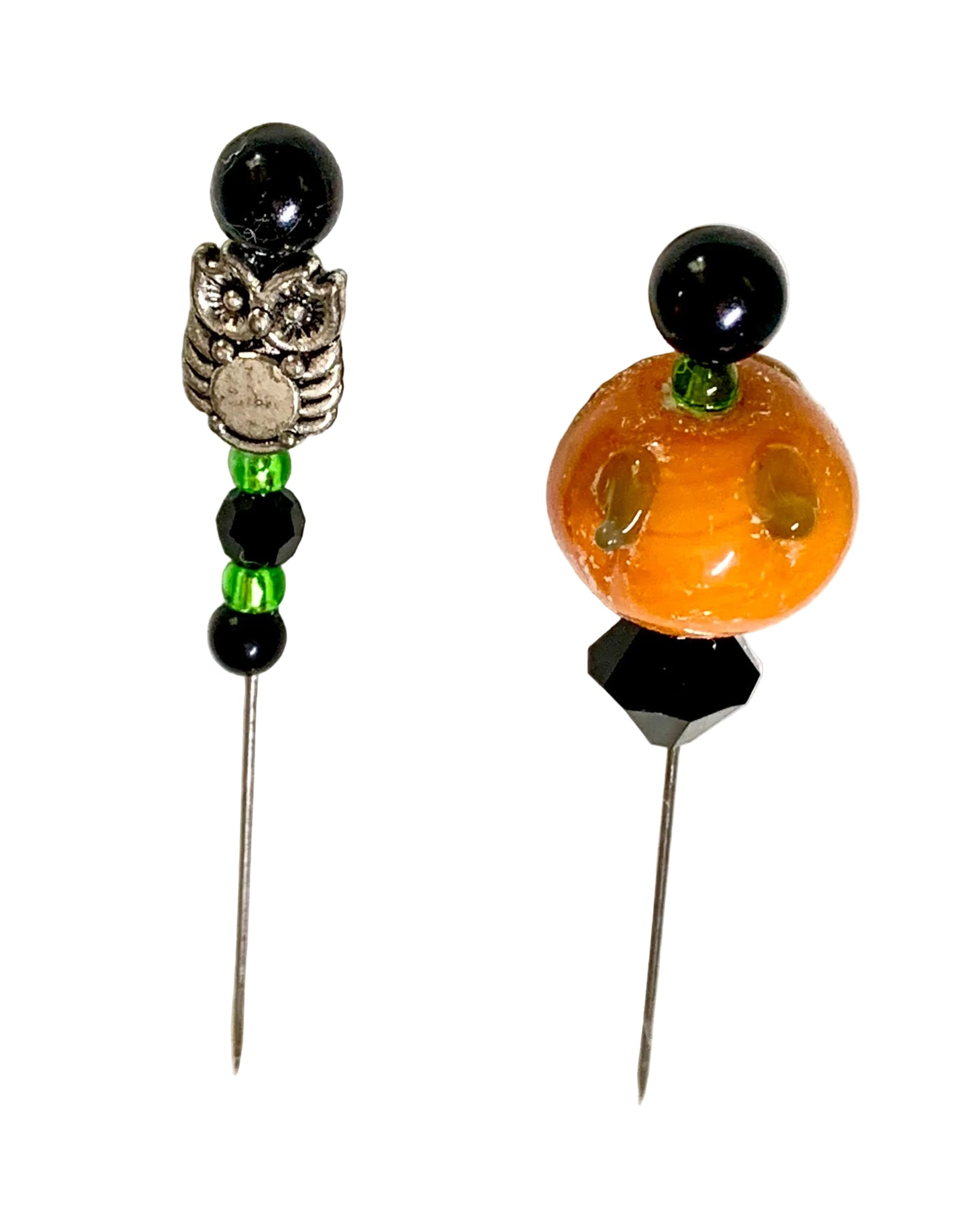 Two Halloween-themed beaded pins on a white background. One pin features a silver-toned owl charm, black beads, and green accent beads. The other is a pumpkin.
[additional_image_link]