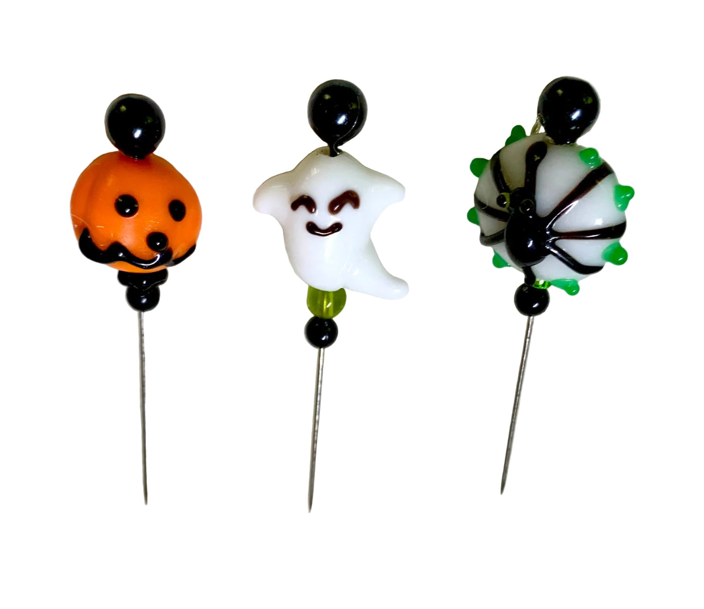 Three Halloween-themed glass bead pins on metal needles, featuring a spider, a smiling ghost, and a jack-o'-lantern, displayed on a white background.
[additional_image_link]