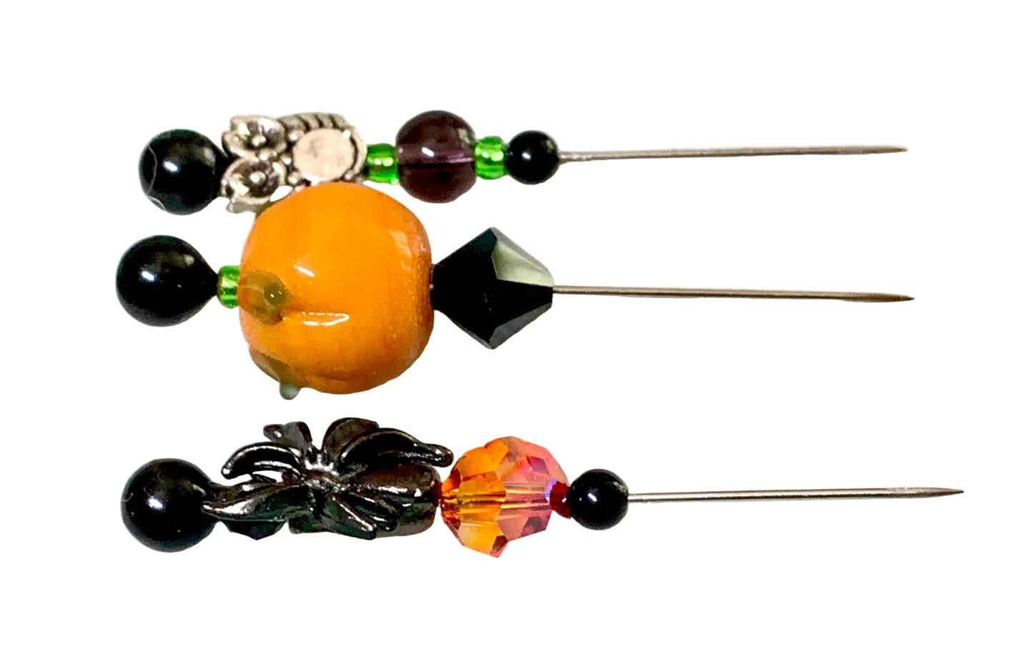 Three decorative sewing pins with assorted beads and metal accents, a spider, a pumpkin, and a silver owl displayed on a white surface.
[additional_image_link]