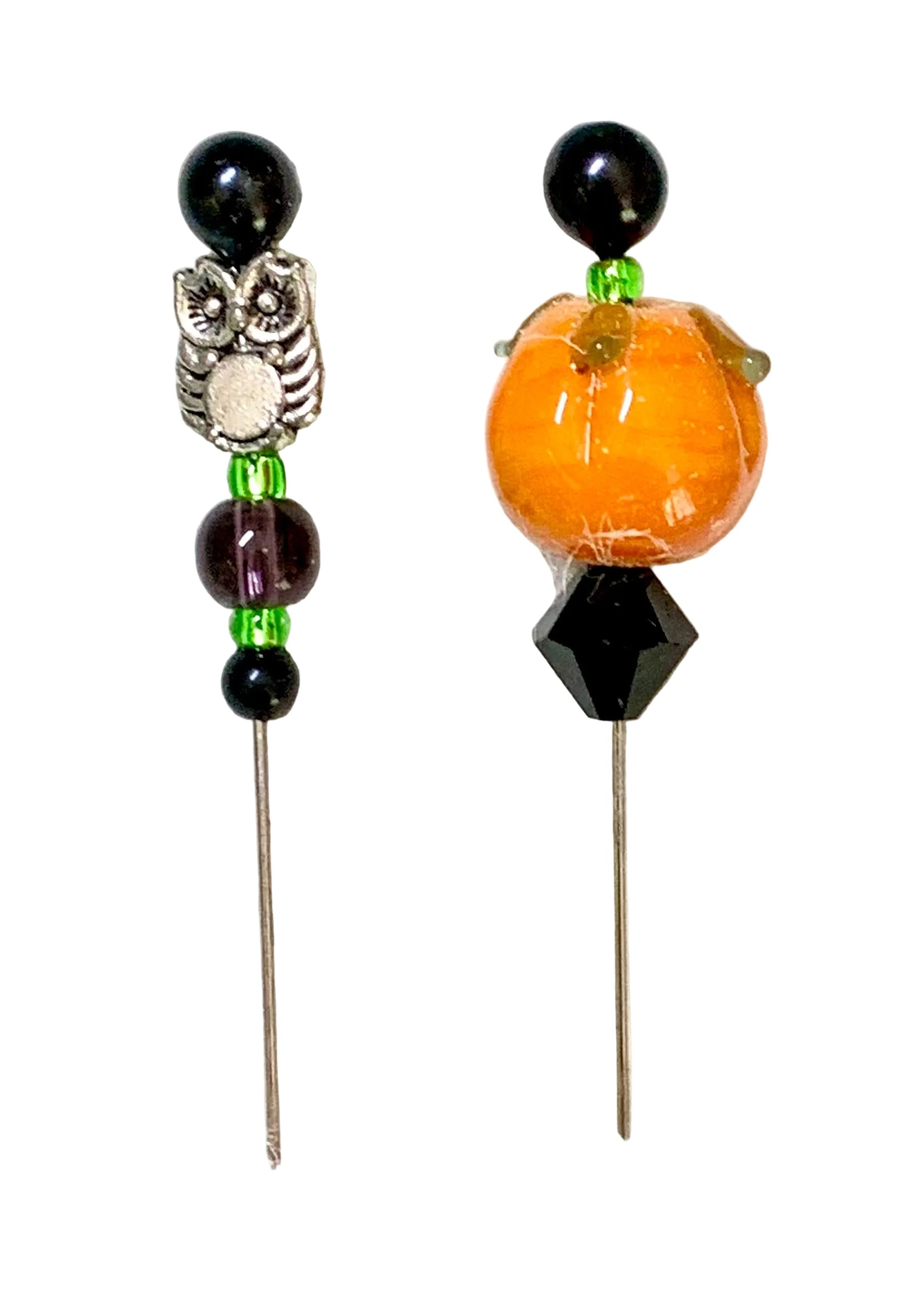 Two Halloween-themed beaded pins on a textured white background. One pin features a silver owl charm with black beads and green accents. The other pin is a pumpkin.
[additional_image_link]