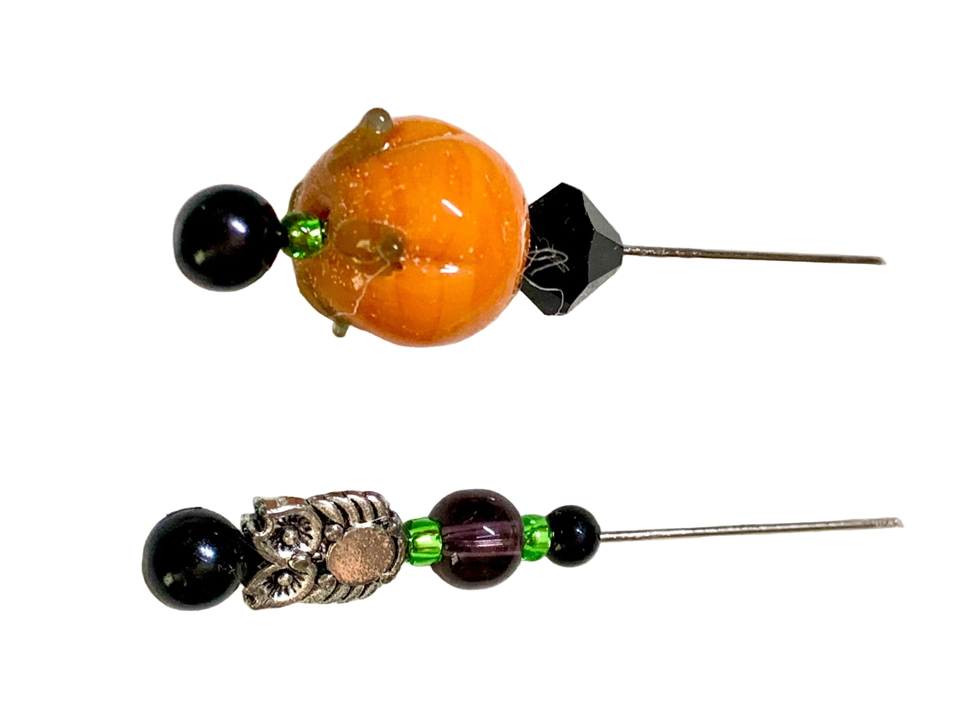Two beaded hair pins on a white background. The top pin features a large orange glass bead, a black faceted bead, and a small green accent. The bottom bead is a silver owl.
[additional_image_link]