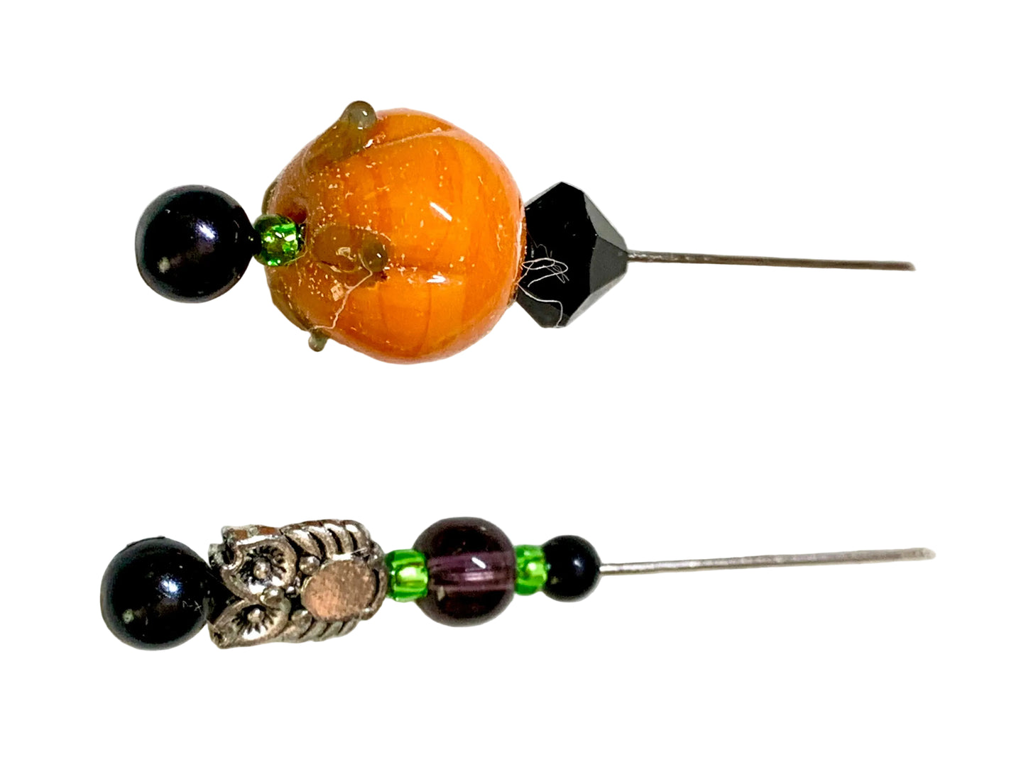 Two beaded hair pins displayed on a plain white background. The top pin features a large orange pumpkin-shaped bead, a black faceted bead, and a small green accent.
[additional_image_link]