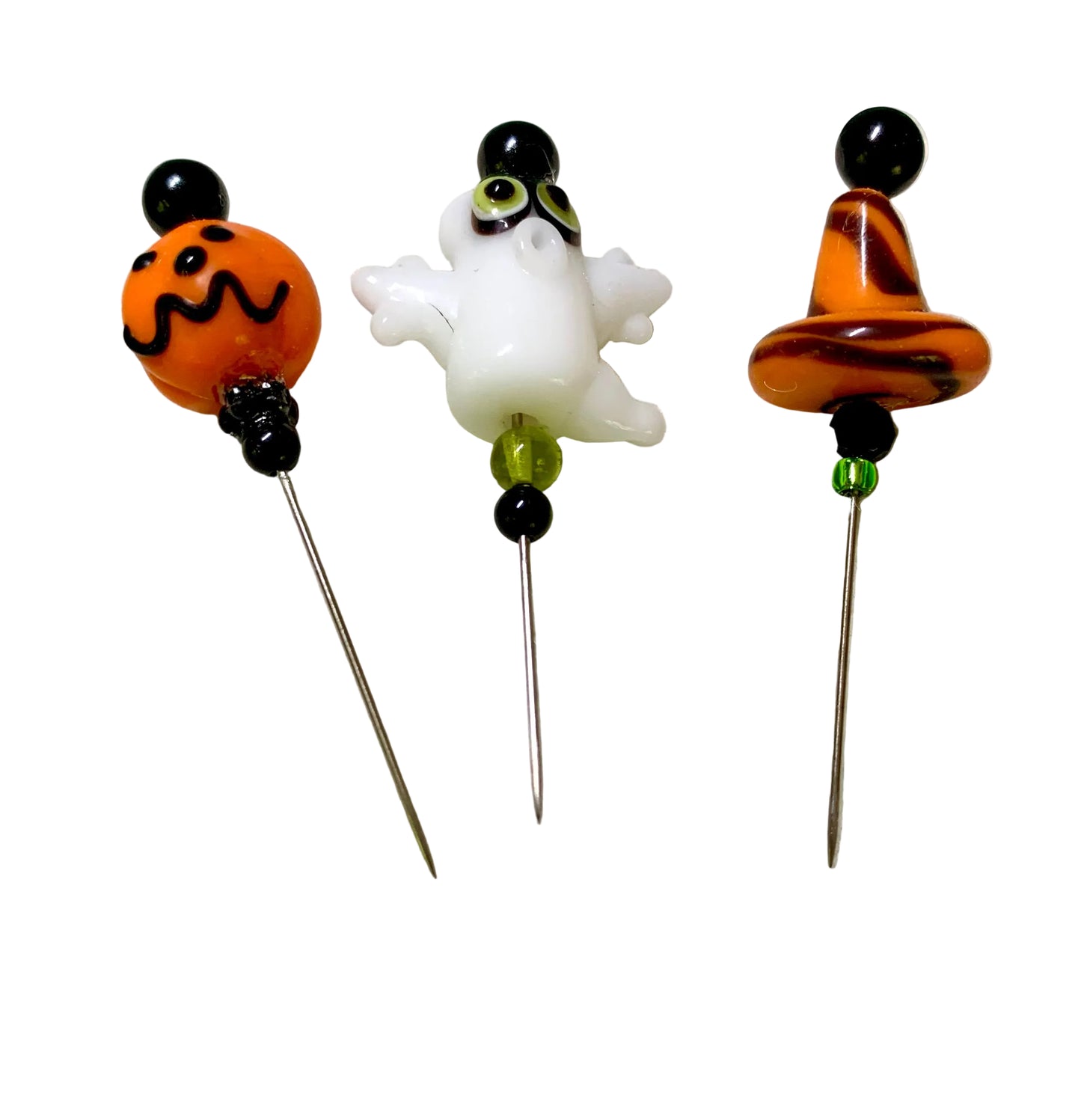 Three Halloween-themed glass pins, displayed on a white surface. Pins feature a Jack-o-lantern head , a Ghost, an orange Witch Hat. 
[additional_image_link]