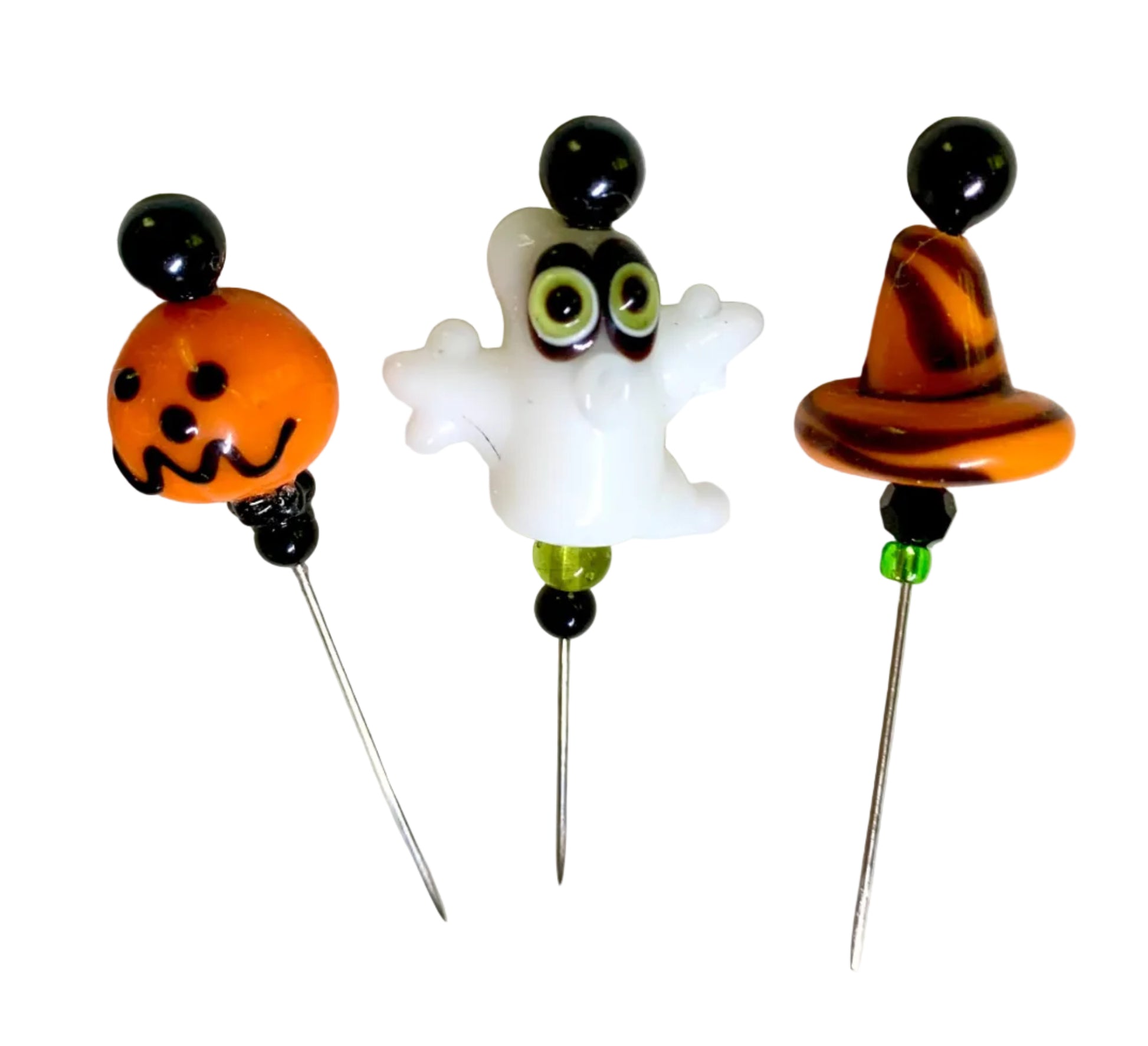 Three Halloween-themed glass bead pins featuring an orange witch hat, a white ghost with green eyes, and an orange jack-o'-lantern, displayed on a white background.
[additional_image_link]