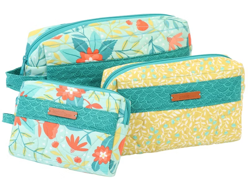 Three quilted makeup pouches from J.Crew in a floral and patterned fabric set, featuring teal, yellow, and light blue colors with brown leather brand patches.
Photo by Annie [additional_image_link]