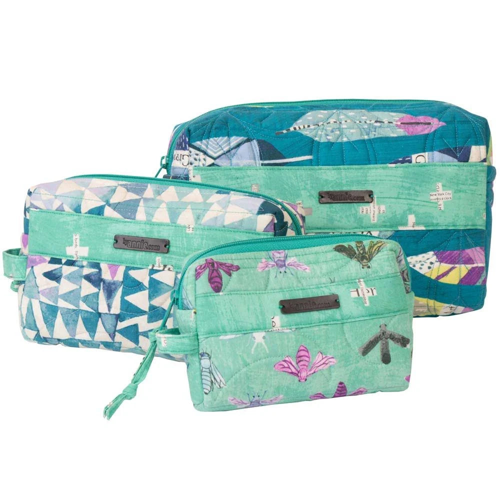 Three quilted travel pouches in a matching teal and mint green butterfly print set, including a large duffel bag, a medium zippered pouch, and a small wristlet, shown on a white background.
Photo by Annie [additional_image_link]