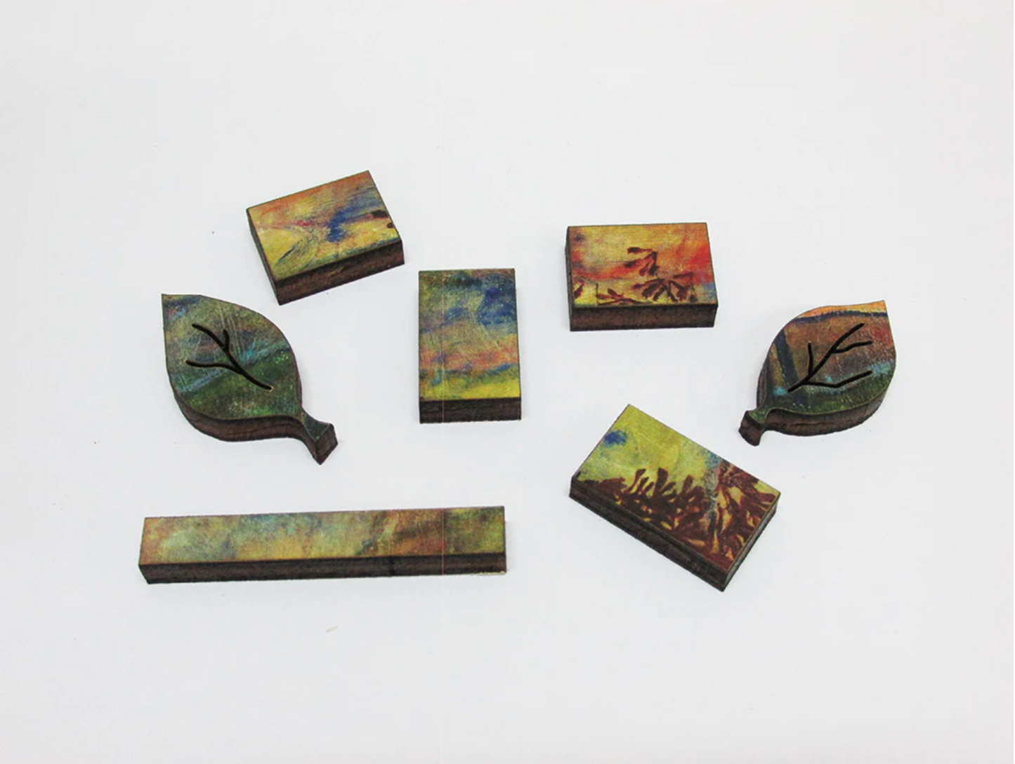 A jigsaw puzzle depicting a vibrant painting of four trees against a sunset background, with a cloudy sky in the background.
Photo by Artifact Puzzles [additional_image_link]
