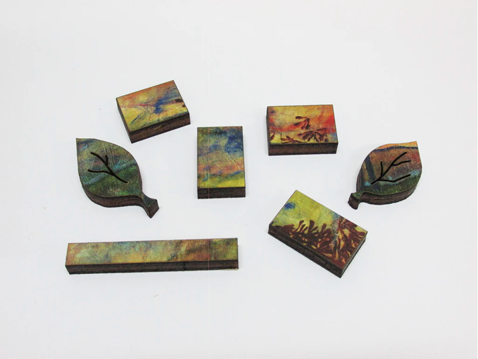 A jigsaw puzzle depicting a vibrant painting of four trees against a sunset background, with a cloudy sky in the background.
Photo by Artifact Puzzles [additional_image_link]