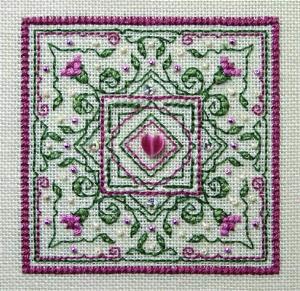 Colorful cross stitch kit image featuring a detailed floral pattern with a central bead and side embellishments, labeled as 'Evening Primrose' from The Sweetheart Tree.
Photo by The Sweetheart Tree [additional_image_link]