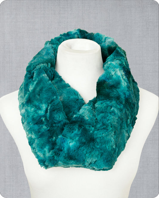 A plush faux-fur infinity scarf in a rich teal green color, displayed on a white mannequin torso against a textured gray background.
Photo by Shannon Fabrics [image_link]