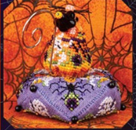A Halloween-themed needlepoint or cross-stitch design featuring a black spider on a purple pillow-like base with a colorful spiderweb-patterned body above it, set against an orange spiderweb background.
Photo by JustNan.com [additional_image_link]