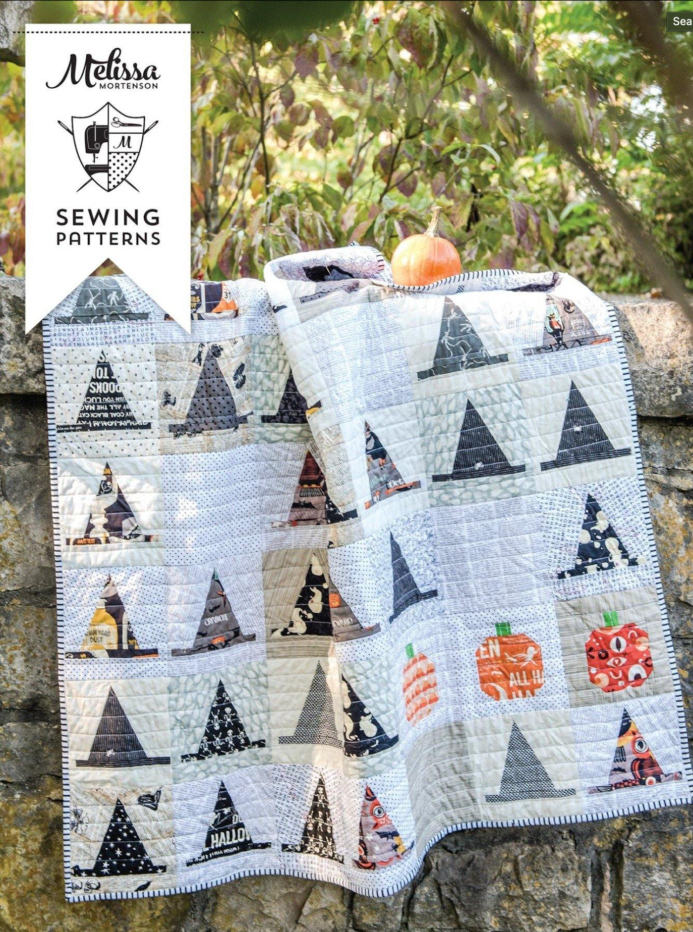 A quilt with a pattern featuring witch hats and pumpkins, in a Halloween-themed design.
Photo by Polka Dot Chair [image_link]