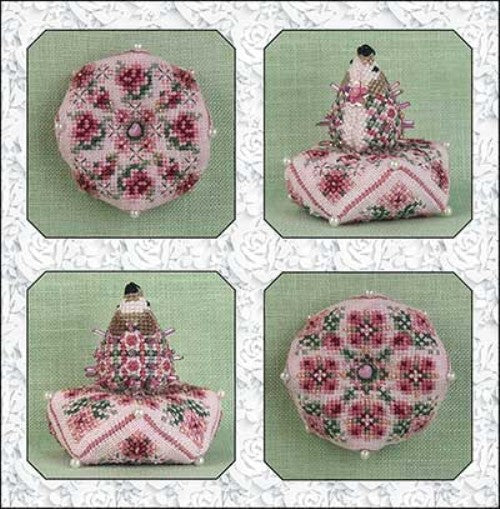 A cross stitch embroidery pattern featuring a pink hedgehog with rose garden designs on a biscornu shape, with embellishments such as pink and gold crystal beads, and a pink quartz heart bead.
Photo by JustNan.com [image_link]