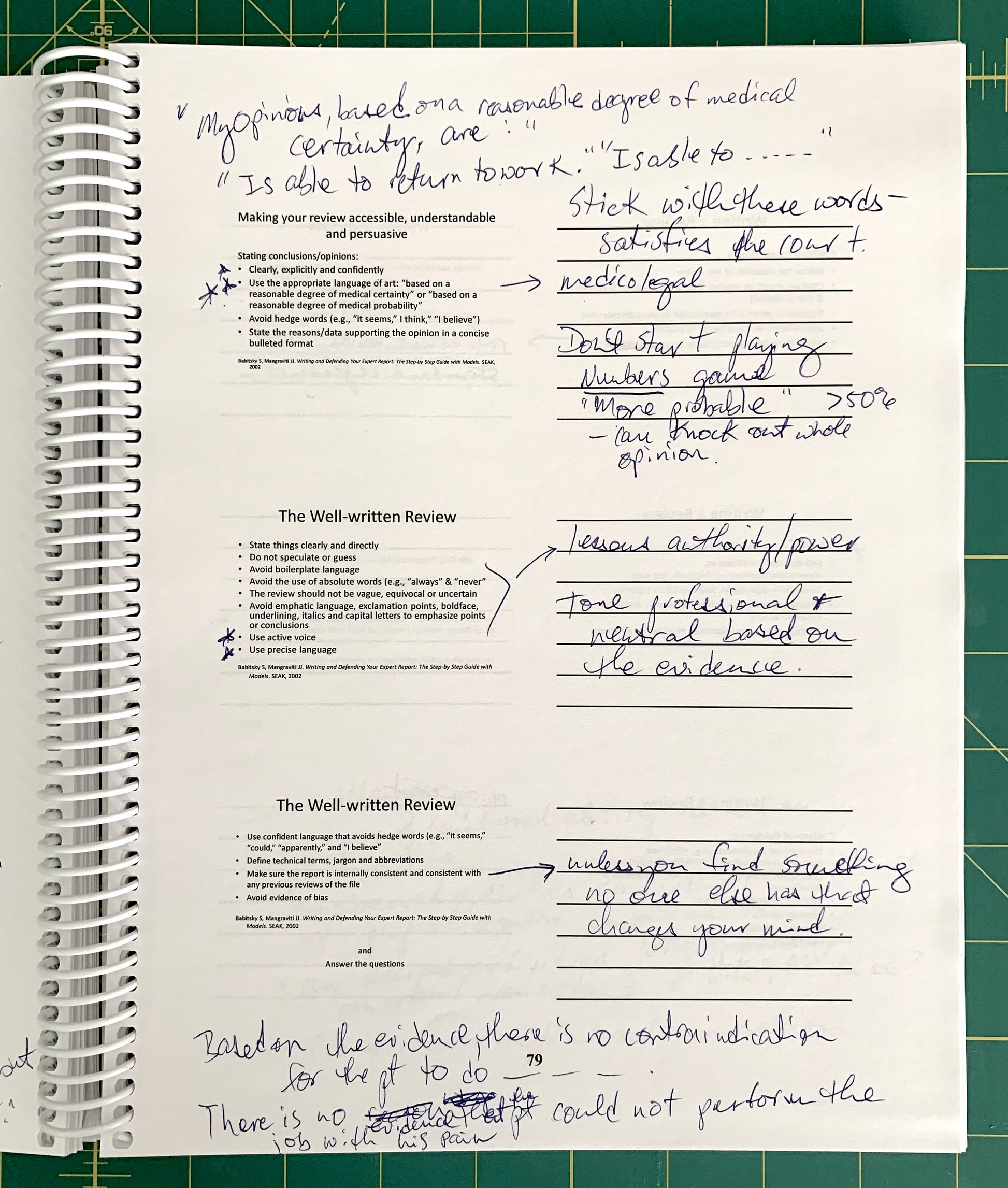 An open spiral-bound notebook showing handwritten notes and printed text pages, photographed on a green cutting mat background.
[additional_image_link]