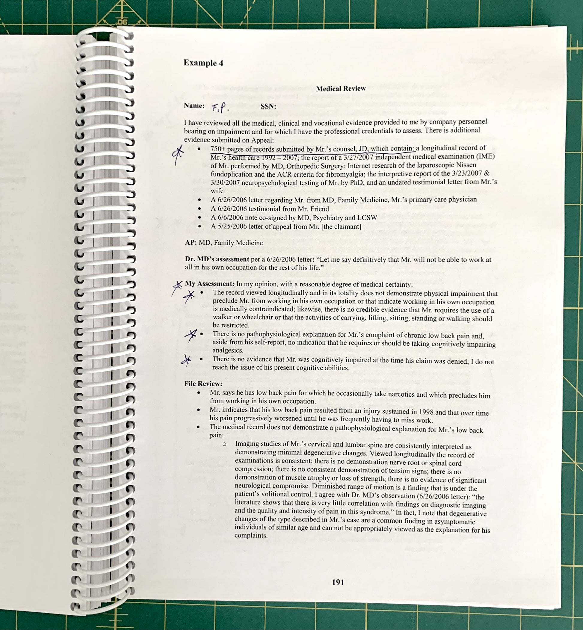 An open spiral-bound medical review notebook showing handwritten notes and printed text on an open page, placed on a green cutting mat background.
[additional_image_link]