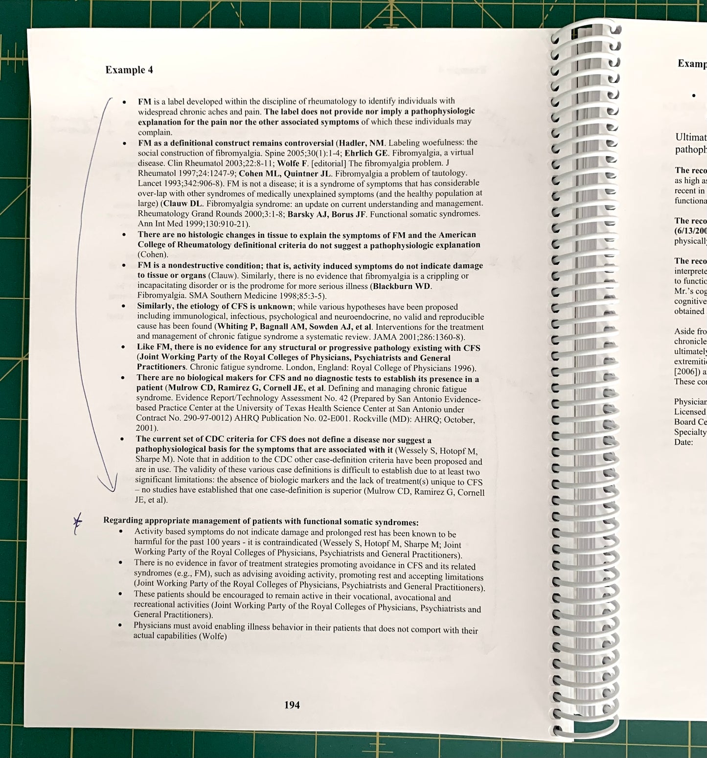 A spiral-bound notebook page showing a handwritten medical case study titled 'Example 4' with printed text and blue ink notes, placed on a green cutting mat.
[additional_image_link]