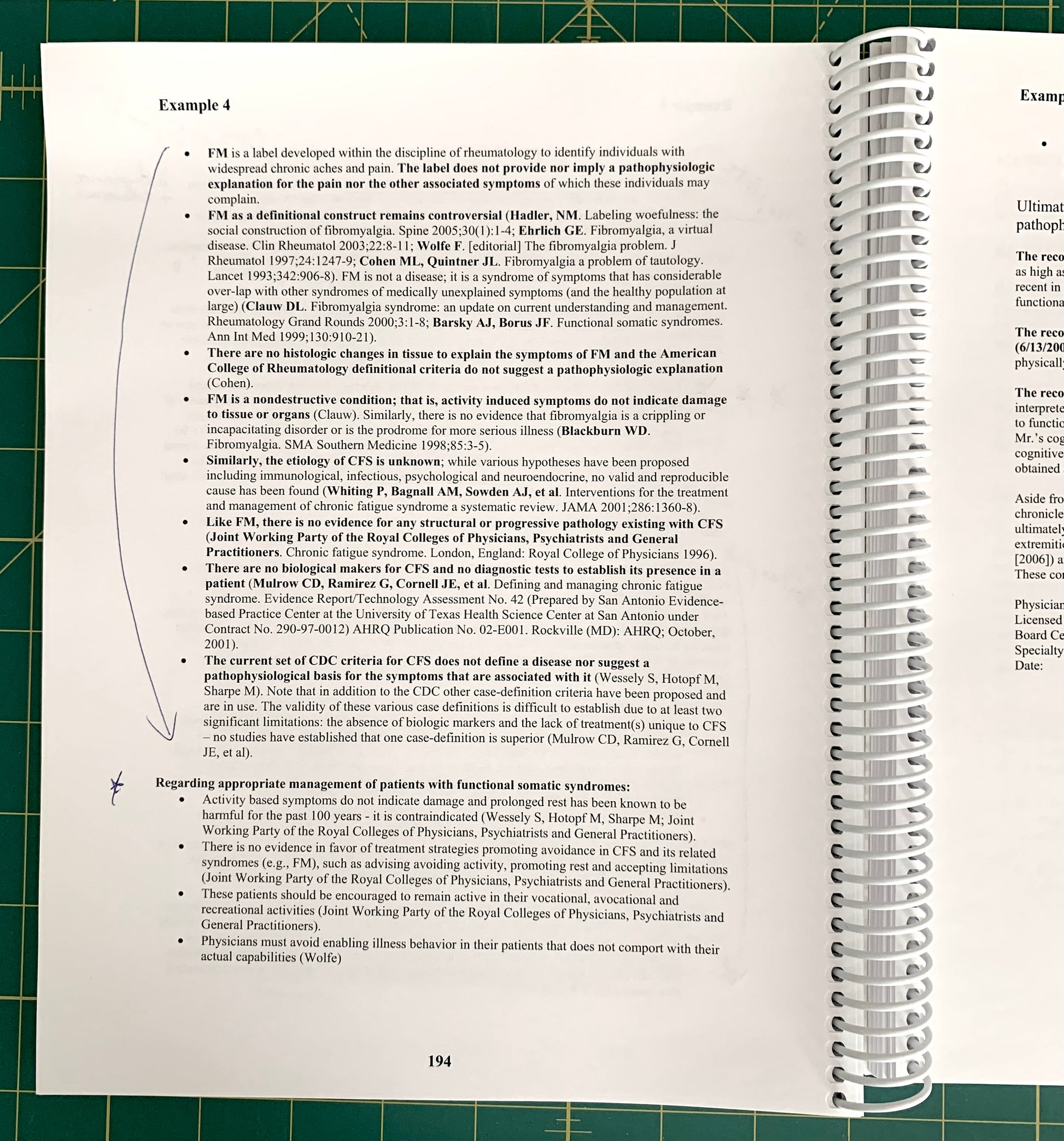 A spiral-bound notebook page showing a handwritten medical case study titled 'Example 4' with printed text and blue ink notes, placed on a green cutting mat.
[additional_image_link]