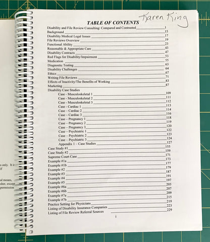 A spiral-bound spiral notebook showing an open table of contents page, photographed on a green cutting mat. The page has black text and a handwritten name 'Karen King' at the top.
[additional_image_link]