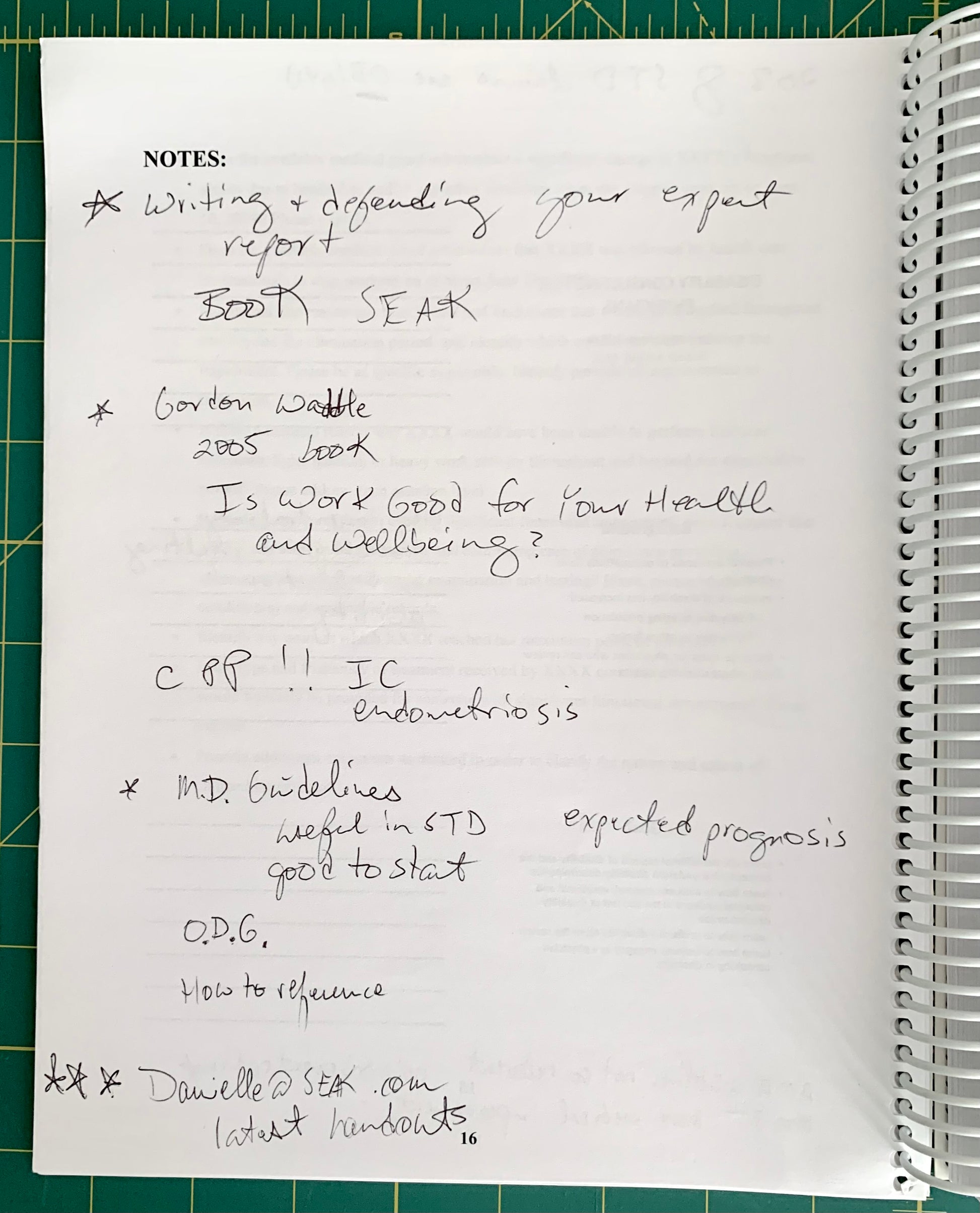 A handwritten notebook page with notes about books, health, and references, photographed on a green cutting mat next to a spiral notebook.
[additional_image_link]