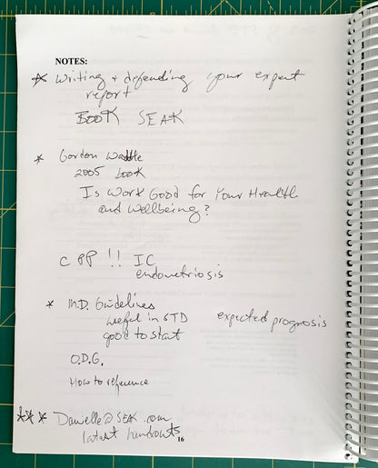 A handwritten notebook page with notes about books, health, and references, photographed on a green cutting mat next to a spiral notebook.
[additional_image_link]