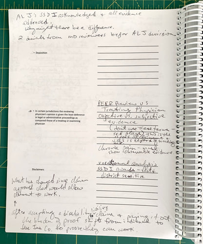 A handwritten legal document or memo page printed on a spiral-bound notebook, placed on a green cutting mat. The page contains typed legal text and multiple handwritten sections with initials and notes.
[additional_image_link]
